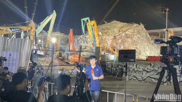 Phóng viên tác nghiệp tại hiện trường sập tòa nhà 30 tầng. (Ảnh: XUÂN SƠN)