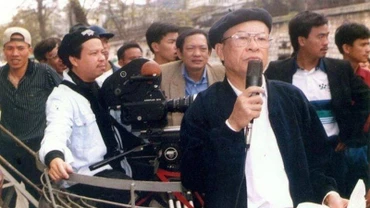 Đạo diễn, NSND Bùi Đình Hạc (người cầm mic) tại trường quay phim "Hà Nội 12 ngày đêm". (Ảnh tư liệu)