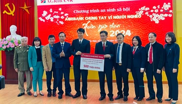 Giám đốc chi nhánh Agribank Bắc Yên Bái trao biểu trưng 500 triệu đồng cho người nghèo tỉnh Yên Bái. (Ảnh: THANH SƠN)