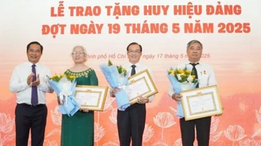 Chủ tịch Ủy ban nhân dân Thành phố Hồ Chí Minh Nguyễn Văn Được trao Huy hiệu 45 năm tuổi đảng cho các đảng viên. (Ảnh: LÊ VĨNH)