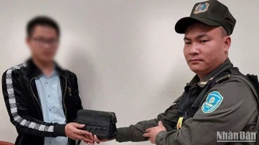 Nhân viên an ninh hàng không Nội Bài trao trả chiếc ví trị giá 120 triệu đồng cho hành khách bỏ quên.