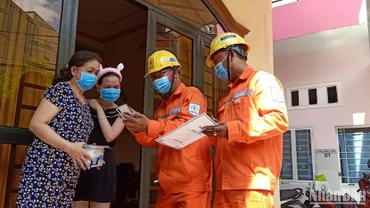 Công nhân ngành điện tuyên truyền cho các gia đình về tiết kiệm điện và giá bán điện theo quy định hiện hành. 