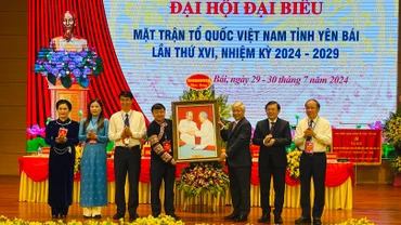 Đồng chí Đỗ Văn Chiến trao tặng bức tranh cho đại hội. (Ảnh: THANH SƠN)