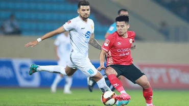 Nỗ lực đi bóng của cầu thủ Công an Hà Nội (áo đỏ) trước Thép Xanh Nam Định. 