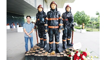 Nghệ sĩ Nguyễn Văn Tuệ bên tác phẩm “Anh hùng”.