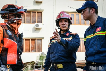 Đại tá Nguyễn Minh Khương (ở giữa) trao đổi với đại diện đoàn cứu nạn, cứu hộ quốc tế tại Myanmar. 