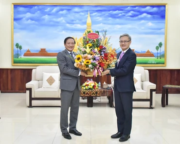 Đại sứ Nguyễn Bá Hùng chúc mừng Trưởng Ban Đối ngoại Trung ương Đảng Nhân dân Cách mạng Lào Thongsavanh Phomvihane. (Ảnh: Trịnh Dũng)