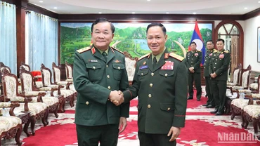 Thượng tướng Hoàng Xuân Chiến chào Bộ trưởng Quốc phòng Lào Khamlieng Outhakaysone. (Ảnh: TRỊNH DŨNG)