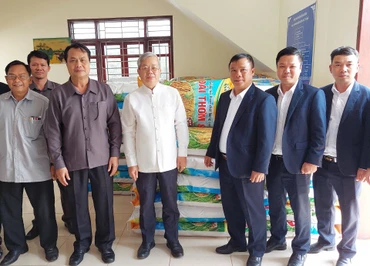 Đại diện lãnh đạo Công ty 705/Quân khu 2 bàn giao 10 tấn thóc giống cho chính quyền tỉnh Oudomxay (Lào). (Ảnh: Hải Tiến)