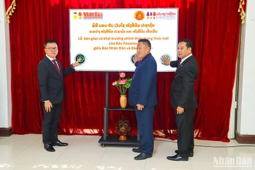Đồng chí Lê Quốc Minh cùng lãnh đạo báo Pasaxon và lãnh đạo Ban Tuyên huấn Trung ương Đảng Nhân dân Cách mạng Lào nhấn nút khai trương báo Pasaxon điện tử mới. (Ảnh: TRỊNH DŨNG)