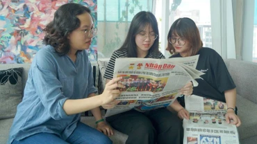 Các bạn trẻ tại Thành phố Hồ Chí Minh đón đọc Báo Nhân Dân. (Ảnh: THẾ ANH)