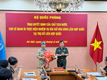 Thượng tướng Hoàng Xuân Chiến trao Quyết định của Chủ tịch nước và tặng hoa chúc mừng Thượng tá Trương Anh Tuấn đi thực hiện nhiệm vụ tại Trụ sở Liên hợp quốc.