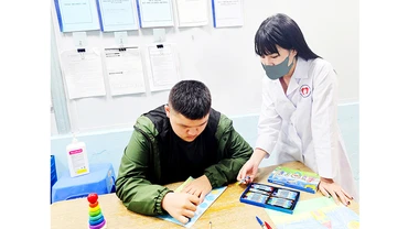 Hướng dẫn bệnh nhân vẽ tranh để phục hồi chức năng. Ảnh: HẢI NAM