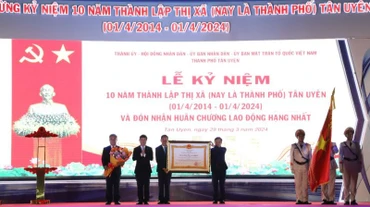 Thừa ủy nhiệm, Chủ tịch Ủy ban nhân dân tỉnh Bình Dương Võ Văn Minh (thứ 2 từ trái sang) trao Huân chương Lao động hạng Nhất cho lãnh đạo thành phố Tân Uyên. 