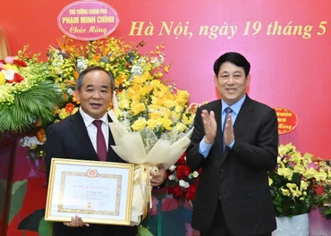 Chủ tịch nước Lương Cường trao Huy hiệu 40 năm tuổi Đảng, tặng hoa chúc mừng Chủ nhiệm Văn phòng Chủ tịch nước Lê Khánh Hải.