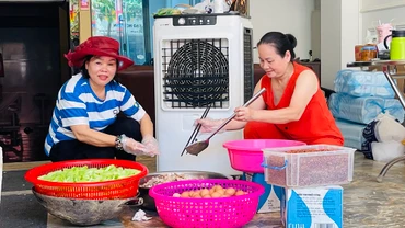 Bà Lý (bìa trái) tham gia chia khẩu phần thức ăn phục vụ bữa trưa 18/9. (Ảnh: THANH SƠN)