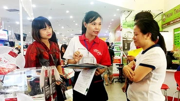Khách hàng tìm hiểu về tiện ích của thẻ tín dụng. Ảnh: NAM HẢI