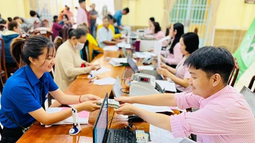 Cán bộ NHCSXH giải ngân nguồn vốn ưu đãi cho các đối tượng chính sách. (Ảnh VIỆT HẢI) 