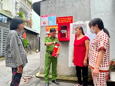 Công an phường Tân Chánh Hiệp (Quận 12, Thành phố Hồ Chí Minh) hướng dẫn người dân sử dụng bình chữa cháy để bảo đảm Tổ liên gia phòng cháy, chữa cháy hoạt động hiệu quả.