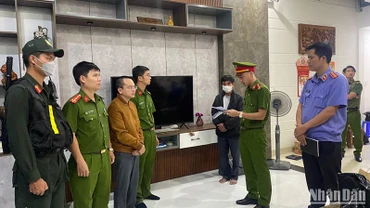 Cơ quan điều tra tống đạt quyết định khởi tố bị can và thực hiện lệnh bắt tạm giam đối với Hoàng Quang Huy (thứ 3 từ trái qua) tối 9/2. (Ảnh: Công an cung cấp).