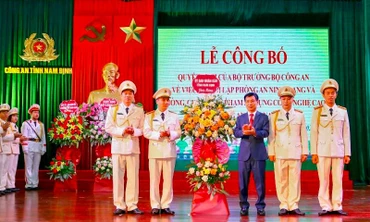Đồng chí Phạm Đình Nghị, Chủ tịch UBND tỉnh Nam Định tặng hoa chúc mừng đại diện Phòng An ninh mạng và phòng, chống tội phạm sử dụng công nghệ cao thuộc Công an tỉnh.