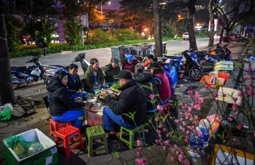 [Ảnh] Ấm cúng bữa cơm tiễn năm cũ bên vỉa hè 