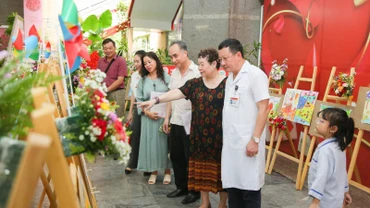Các đại biểu tham quan triển lãm tranh vẽ của các bạn nhỏ mắc bệnh thalassemia.