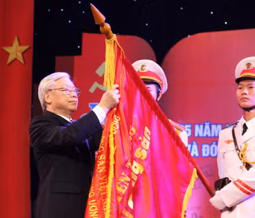 Tổng Bí thư Nguyễn Phú Trọng gắn Huân chương Hồ Chí Minh lần thứ hai lên lá cờ truyền thống của Tạp chí Cộng sản. (Ảnh: Đào Trọng Nguyên)