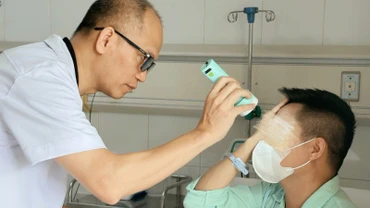 Phó Giáo sư, Tiến sĩ Nguyễn Hồng Hà -Trưởng Khoa Phẫu thuật Hàm mặt, Tạo hình và Thẩm mỹ khám cho bệnh nhân.