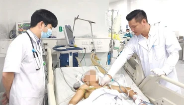 Thạc sĩ, bác sĩ Đồng Phú Khiêm, Phó Giám đốc Trung tâm Hồi sức tích cực, Bệnh viện Bệnh Nhiệt đới Trung ương (trái) thăm khám cho người bệnh.
