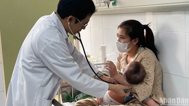 Tiến sĩ, bác sĩ Đỗ Thiện Hải, Phó Giám đốc Trung tâm bệnh Nhiệt đới, Bệnh viện Nhi Trung ương khám cho bệnh nhi mắc sởi. (Ảnh: HẢI NGÔ)