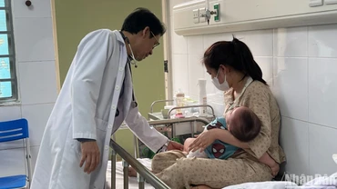 Bác sĩ khám cho bệnh nhi nằm viện do mắc sởi. (Ảnh: HẢI NGÔ)