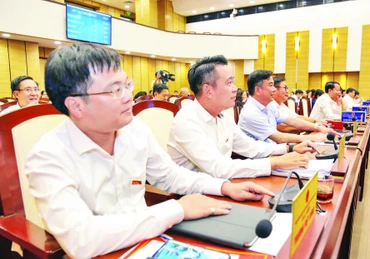 Đại biểu HĐND thành phố biểu quyết thông qua Nghị quyết tại kỳ họp thứ chín, khóa XVI. (Ảnh: MINH HÀ)