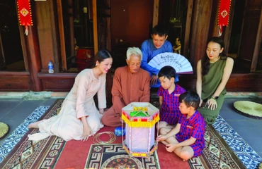 Nghệ nhân Nguyễn Văn Quyền (thứ hai từ trái sang; xã Cao Viên, huyện Thanh Oai, Hà Nội) giới thiệu cách làm đèn kéo quân. 