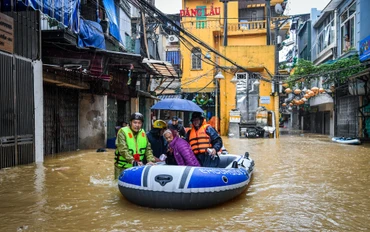 [Ảnh] Phố xá ngập sâu, người dân ven sông Hồng lên thuyền di dời