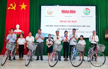 Đồng chí Đinh Như Hoan, Phó Tổng Biên tập Báo Nhân Dân trao tặng xe đạp cho học sinh có hoàn cảnh khó khăn hiếu học tại huyện Vĩnh Linh. (Ảnh: THÀNH ĐẠT)