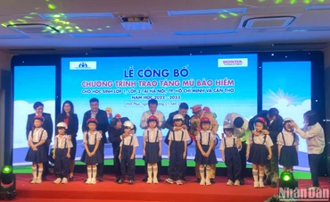 Đại diện ban tổ chức tặng mũ cho các học sinh lớp 1 và lớp 2 tại lễ công bố chương trình.