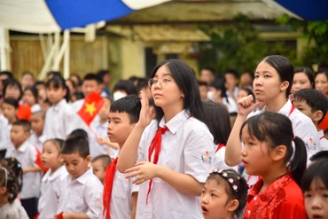 Học sinh trường Phổ thông cơ sở Xã Đàn (Hà Nội) hát quốc ca bằng tay. (Ảnh: NHẬT QUANG)