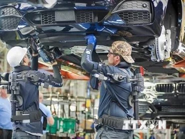 Công nhân làm việc trên dây chuyền sản xuất xe ô tô của Hãng BMW (Đức). (Ảnh: DW/TTXVN)