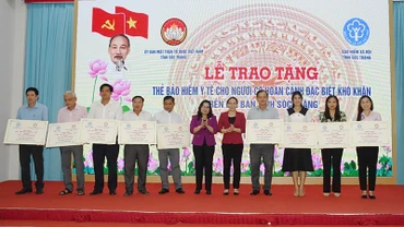 Lãnh đạo tỉnh Sóc Trăng trao bảng tượng trưng tặng thẻ bảo hiểm y tế cho người có hoàn cảnh đặc biệt khó khăn. 
