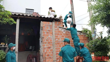 Các lực lượng chức năng giúp người dân thị xã Đức Phổ (Quảng Ngãi) chằng chống nhà cửa.