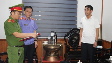 Cơ quan chức năng đọc lệnh bắt bị can để tạm giam đối với ông Doãn Tiến Dũng, Chủ tịch Ủy ban nhân dân thị xã Cửa Lò. (Ảnh: Công an Nghệ An cung cấp)