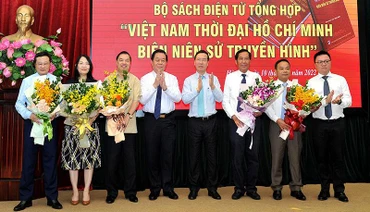 Ủy viên Bộ Chính trị, Thường trực Ban Bí thư Võ Văn Thưởng; Bí thư Trung ương Đảng, Trưởng Ban Tuyên giáo Trung ương Nguyễn Trọng Nghĩa; Ủy viên Trung ương Đảng, Tổng Biên tập Báo Nhân Dân Lê Quốc Minh tặng hoa cho đại diện Ban biên soạn bộ sách. Ảnh: ĐĂNG KHOA