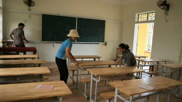 Giáo viên Trường phổ thông dân tộc bán trú tiểu học và trung học cơ sở Nậm Càn, huyện Kỳ Sơn vệ sinh, sửa sang lại bàn ghế các phòng học.