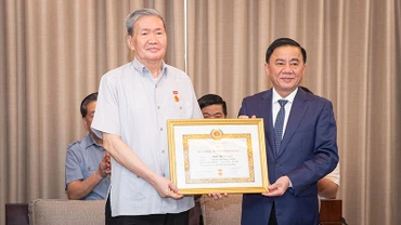 Đồng chí Trần Cẩm Tú trao Quyết định tặng Huy hiệu 50 tuổi Đảng cho đồng chí Đinh Thế Huynh. (Ảnh: SƠN TÙNG)