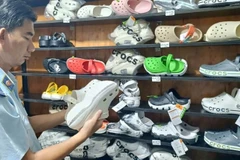 Lực lượng Quản lý thị trường Thành phố Hồ Chí Minh kiểm tra dép có dấu hiệu giả mạo nhãn hiệu tại một hộ kinh doanh.