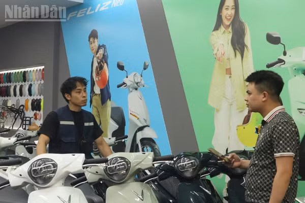Nhân viên một cửa hàng xe máy điện tại Hà Nội giải đáp những nỗi lo của khách hàng khi chuyển qua sử dụng xe máy điện. (Ảnh: ANH DUY)