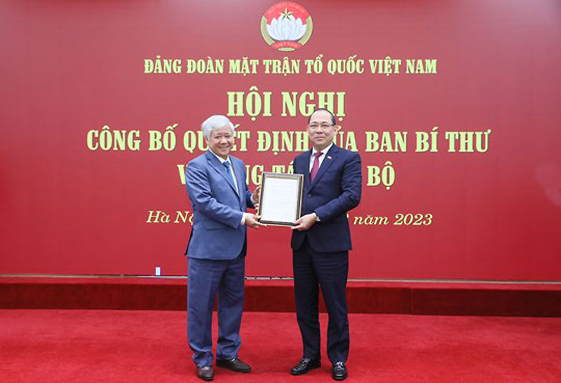 Đồng chí Đỗ Văn Chiến trao Quyết định và tặng hoa chúc mừng đồng chí Hoàng Công Thủy. (Ảnh: DIỆP VINH)