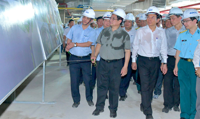 Thủ tướng Phạm Minh Chính nghe giới thiệu về các hạng mục của Nhà ga hành khách T3 đang được xây dựng.