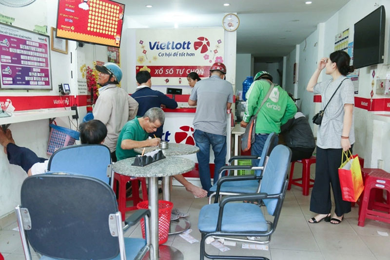 Bên trong một điểm bán vé số Vietlott có đông người chơi theo dõi kết quả mở thưởng Keno trực tiếp trên màn hình lớn.